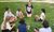 teacher sitting on grass with children