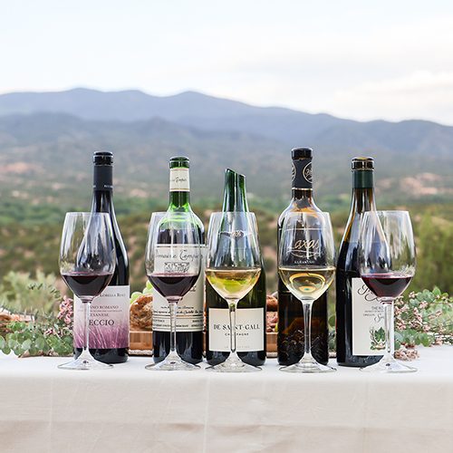 Wine bottles and glasses at a tailgate